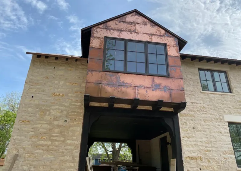 Copper metal panel facade on a stone building for Skylight Installation in Heber